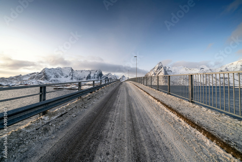 Bridge against snowcapped mountains in Reine, Norway © YUXUAN