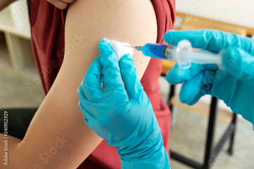 Doctor making a vaccination into patient with needle getting immune vaccine at arm for flu shot  coronavirus protective of epidemic
