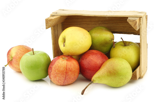 Fresh pears and apples in a wooden crate on a white background
