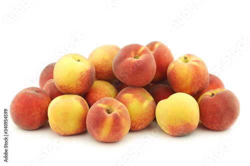  fresh colorful peaches (donut peaches) on a white background