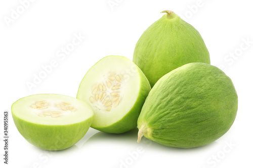 Two cumelo's (mix between a cucumber and a melon) and a cut one on a white background