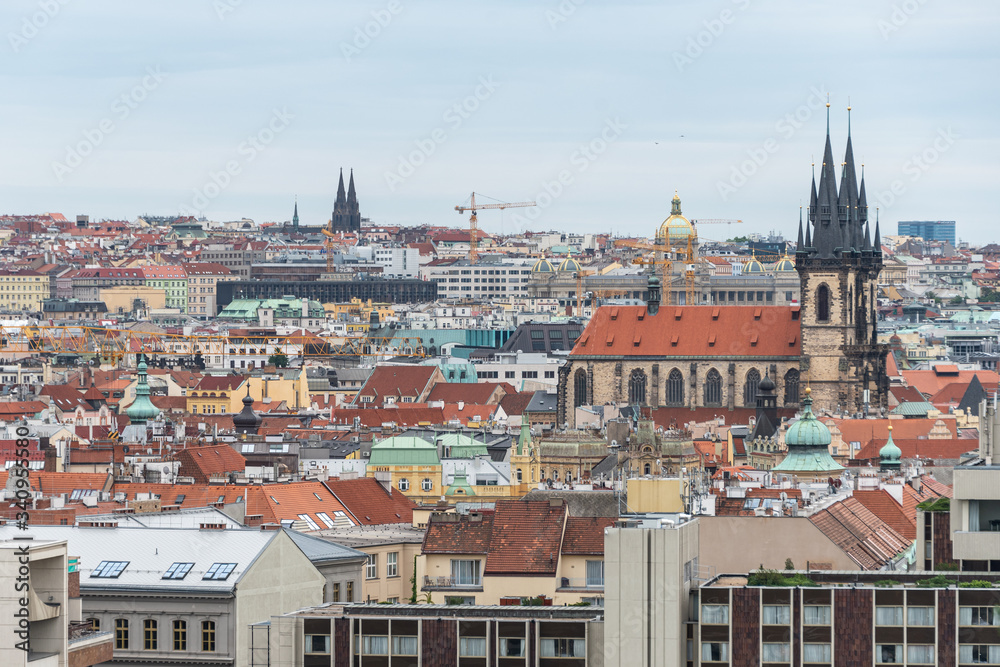 Fototapeta premium Above view of the cityscape of Prague on a sunny day. The detail view of modern and old part of town with traditional red rooftops.
