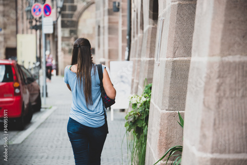 Giovane ragazza che cammina di spalle in una strada di città a Norimberga
