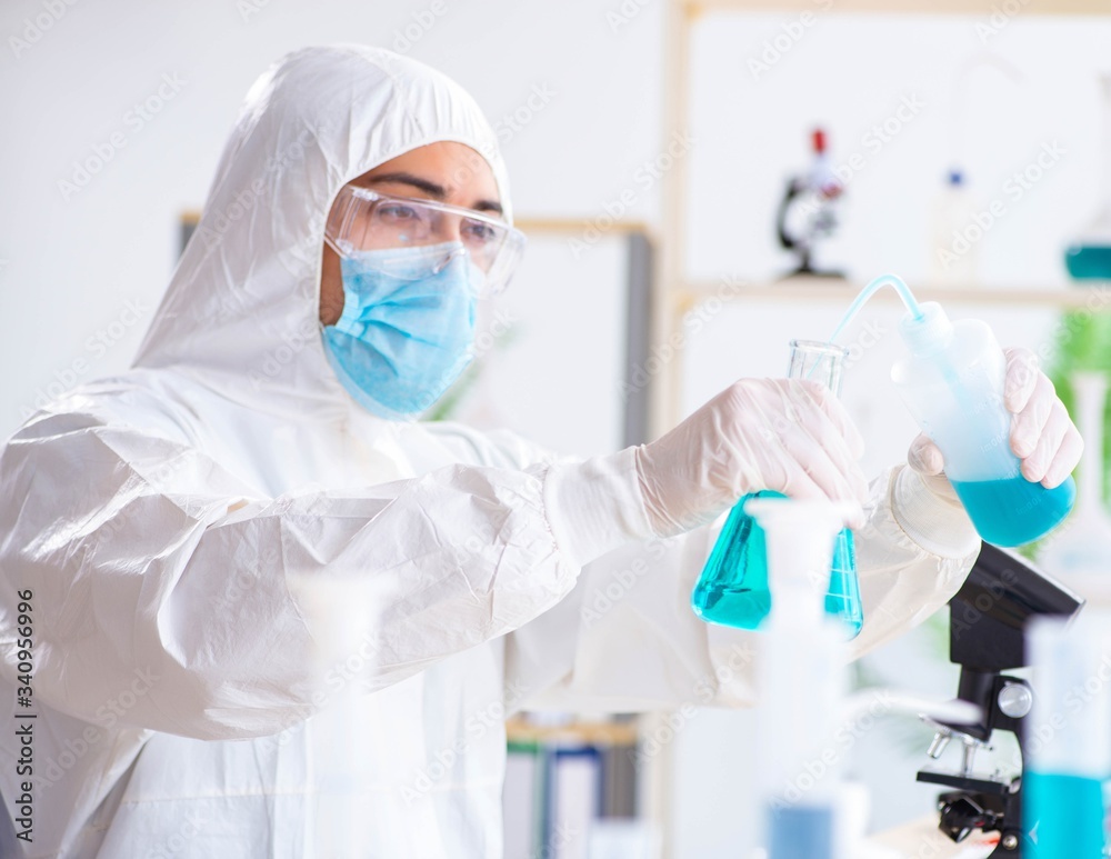 Young chemist student working in lab on chemicals