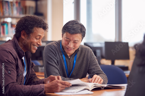 Canvastavla Teacher With Mature Male Adult Student Sitting At Table Working In College Libra