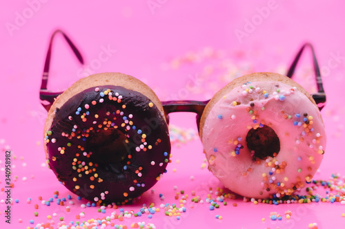 Sweet look. Two pink donuts as an eyewear, glasses on pink background. Copyspace for your ad. Modern design. Contemporary artwork, collage. Concept of summertime, mood, beach season, holiday, funny