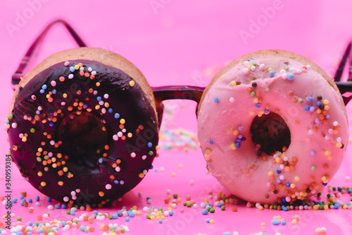 Sweet look. Two pink donuts as an eyewear, glasses on pink background. Copyspace for your ad. Modern design. Contemporary artwork, collage. Concept of summertime, vacation, mood, beach, holiday, funny