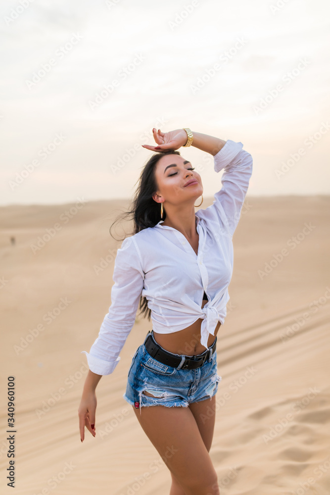Young beautiful woman posing on desert landscape.