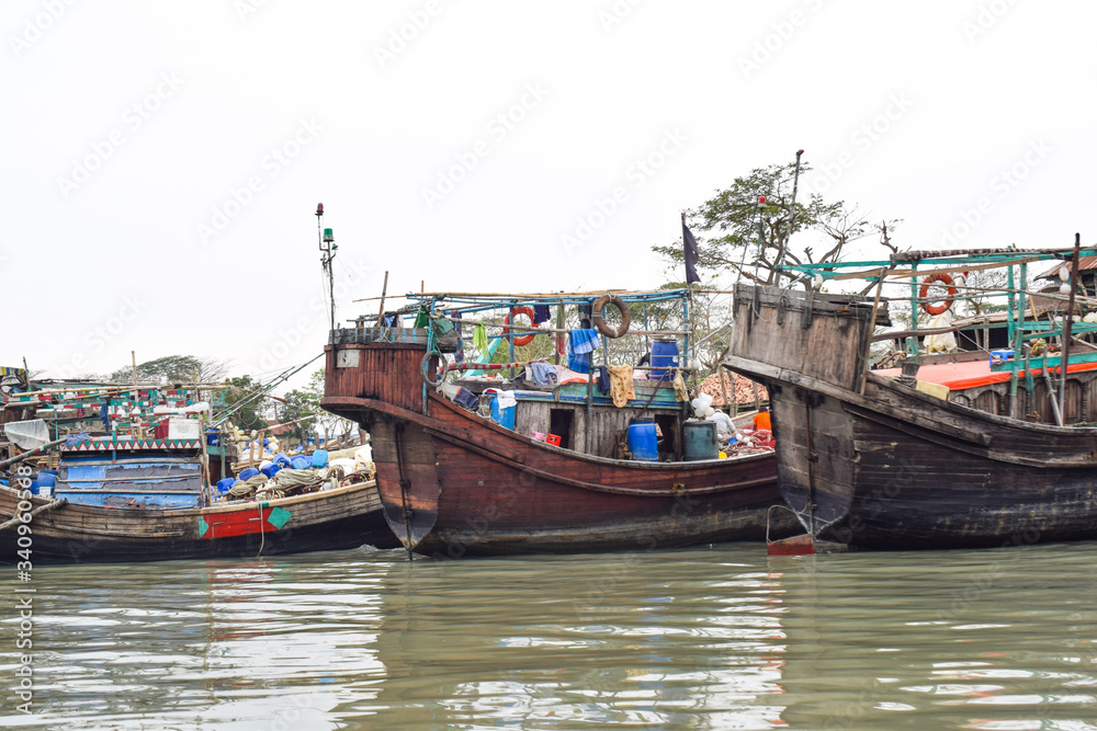 A harbor of different sized wooden fishing boat,where the boats are grounded safely