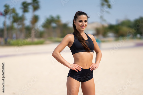 Young beautiful sportive girl standing on the beach before training