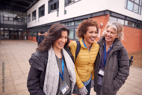 Group Of Smiling Female Mature Students Walking Outside College Building