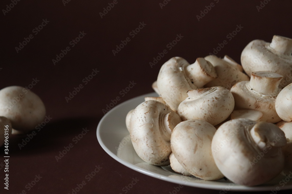 mushrooms on a plate on dark brown background mushrooms on a plate on dark brown background