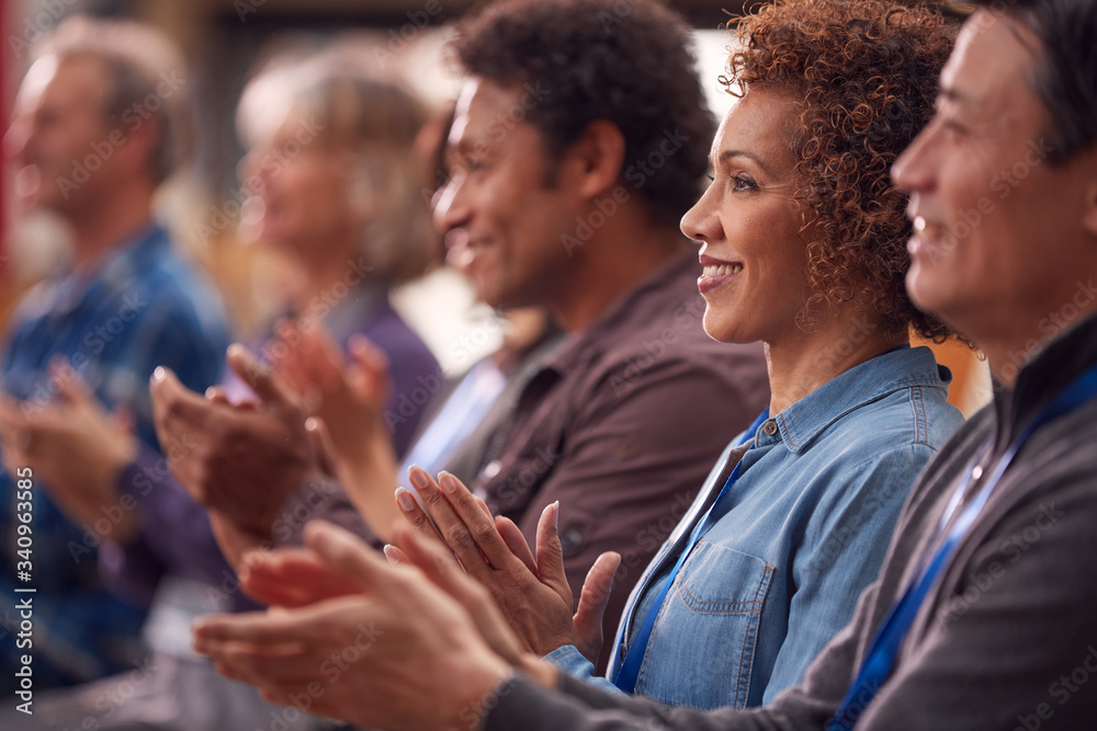 Group Of Casually Dressed Businessmen And Businesswomen Applauding Presentation At Conference Group Of Casually Dressed Businessmen And Businesswomen Applauding Presentation At Conference