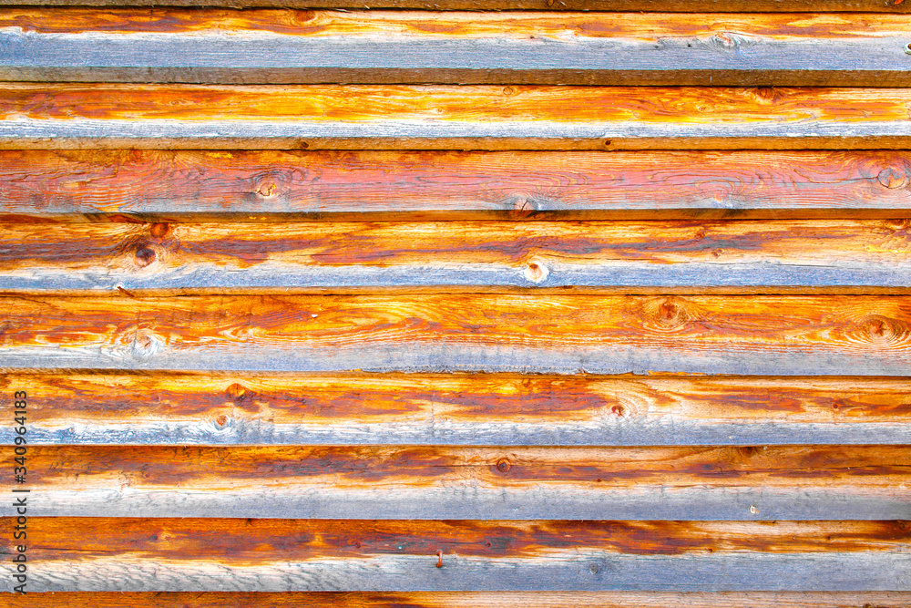 Background textured old wall of brown and orange style wooden beams. The wall of an old country house.