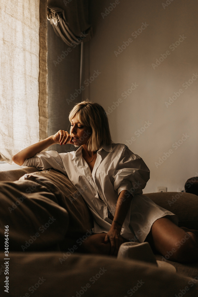 Seductive blonde sitting on sofa in living room Seductive blonde sitting on sofa in living room