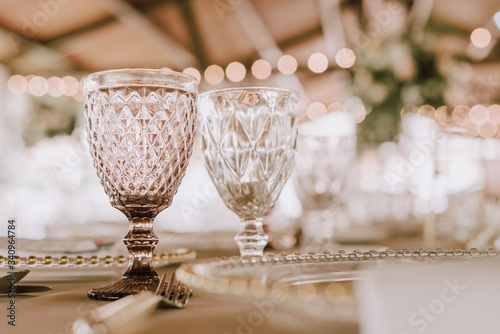 Beautiful empty wineglasses on banquet table on blurred background in modern restaurant 