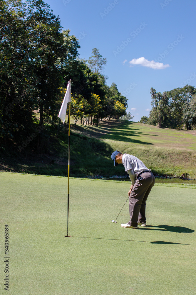 Obraz premium Man playing golf on a golf course.
