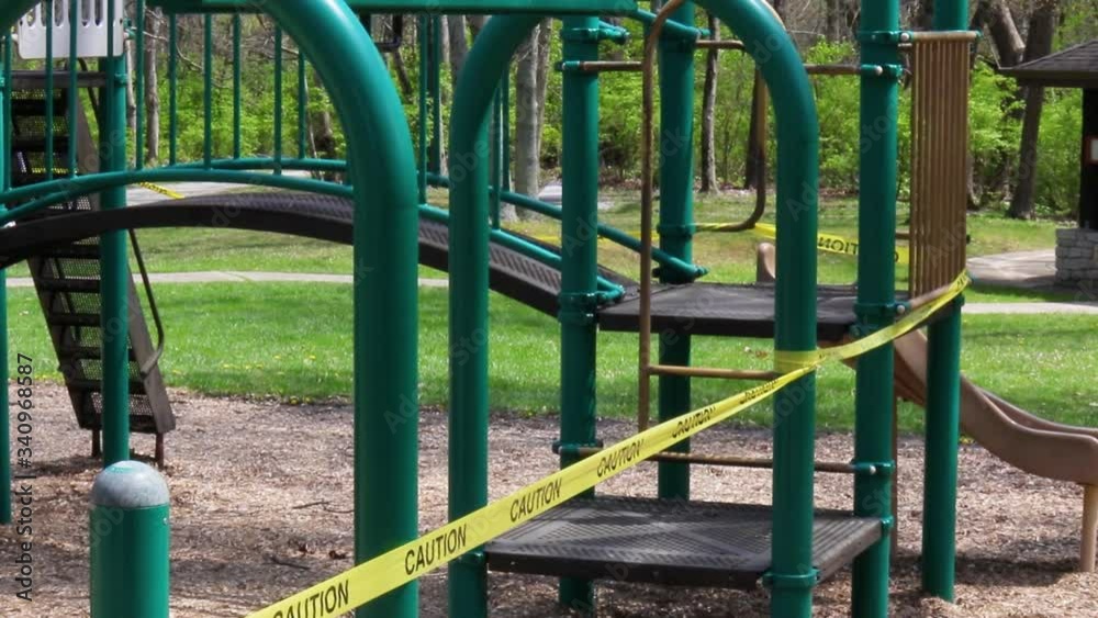 Green playground equipment with caution tape wrapped around it. Green playground equipment with caution tape wrapped around it.