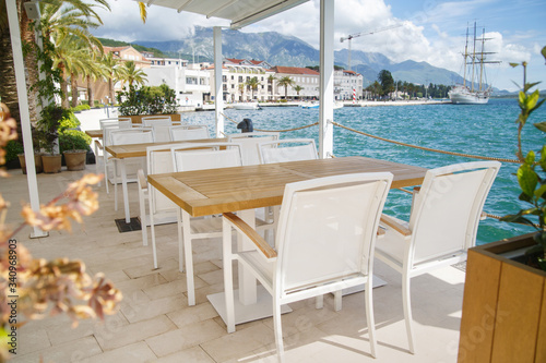 Fototapeta Naklejka Na Ścianę i Meble -  Cozy empty open cafe on the sea promenade, Tivat, Montenegro.