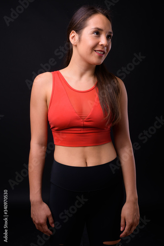Young multi ethnic beautiful woman ready for gym against black background