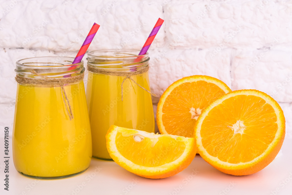 Two glasses of fresh orange juice on a white background. Close-up. Two glasses of fresh orange juice on a white background. Close-up.