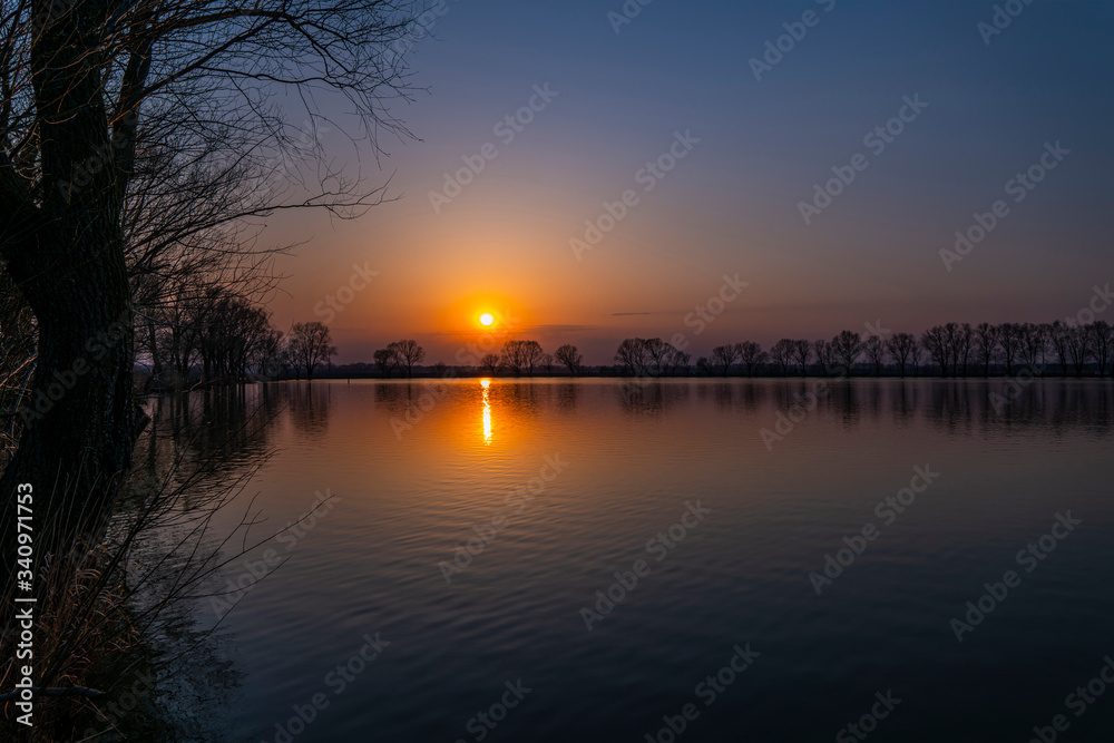 Colorful sunset with clear sky at lake coast. Relax landscape