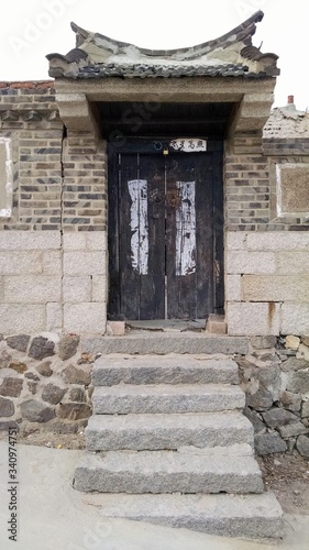 Old Chinese Fisherman House With A Distressed Wooden Door photo