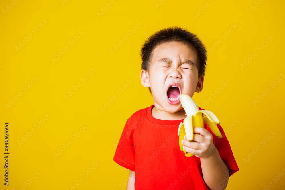 kid cute little boy attractive smile wearing red t-shirt playing holds peeled banana for eating kid cute little boy attractive smile wearing red t-shirt playing holds peeled banana for eating