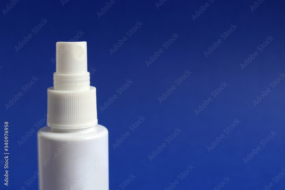 Hand spray, white tube for disinfection on a blue background Hand spray, white tube for disinfection on a blue background