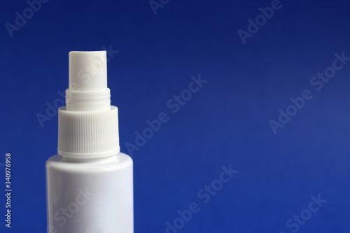 Hand spray, white tube for disinfection on a blue background