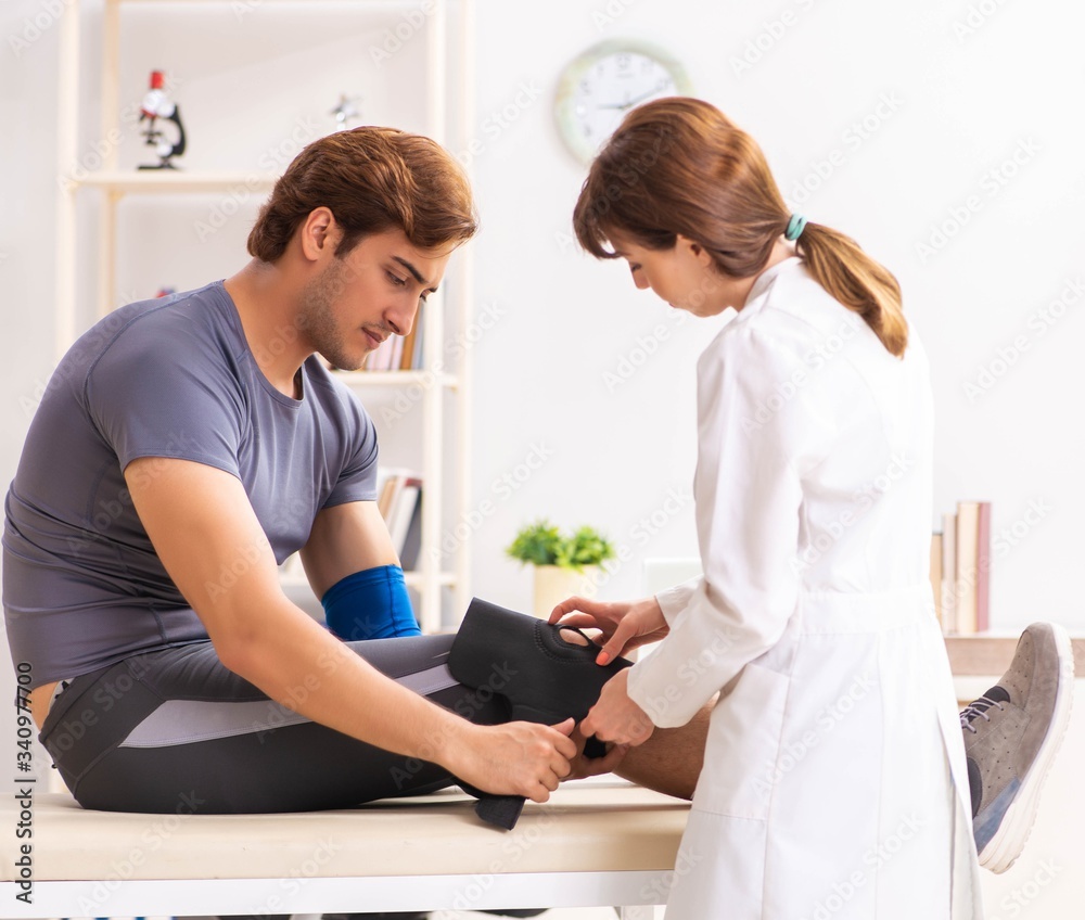 Fototapeta premium Young male patient visiting female doctor traumatologist