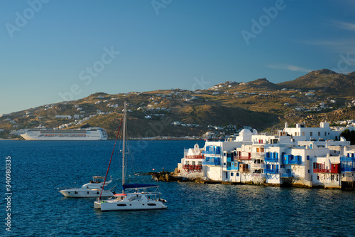 Sunset in Mykonos island, Greece with yachts in the harbor and colorful waterfront houses of Little Venice romantic spot on sunset and cruise ship. Mykonos townd, Greece © Dmitry Rukhlenko