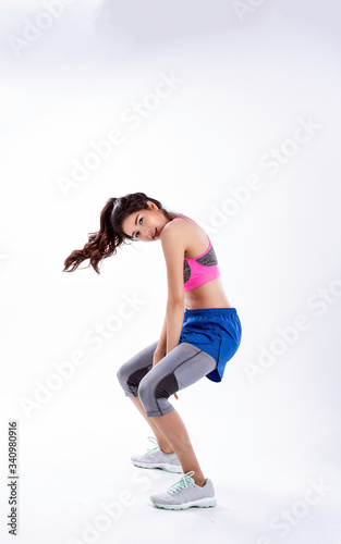 Young beautiful lady wearing sportwear,standing feet apart,kneel and moving body,dance workout for exercise,with happy feeling