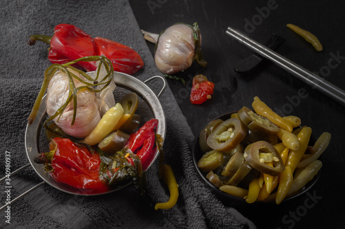 Fermented hot pepper and garlic on a dark wooden table. Low key.