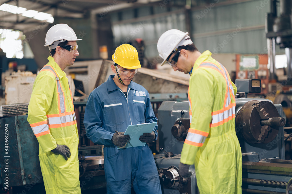 Three technician Mechanic working on Machine in factory Three technician Mechanic working on Machine in factory