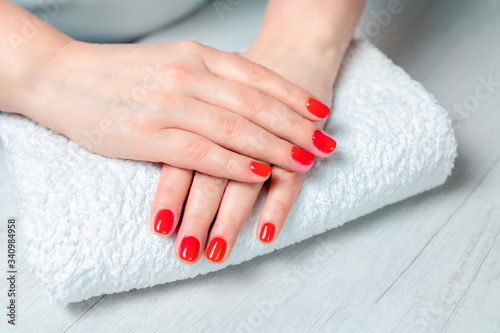 Hands after manicure with red nails and varnish. Manicured nails with red polish. Manicure with bright nail polish.