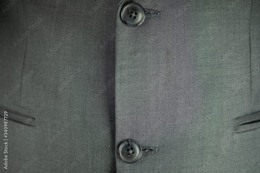 Black button on a man suit background. Black button on a man suit background.