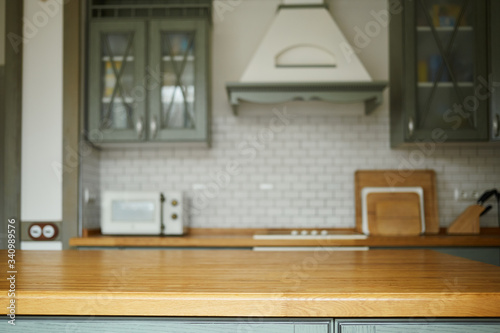 A kitchen island and a kitchen in the background