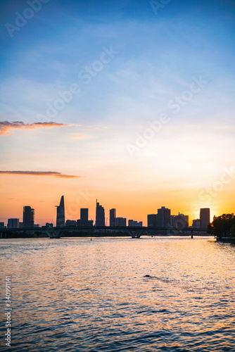 River city view landscape at twilight sunset. Boat on river with tranquil water. Hochiminh city Saigon vietnam cityscape building with Bitexco tower