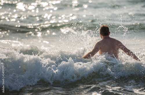 Caucasian Man Diving In Ocean Waves.