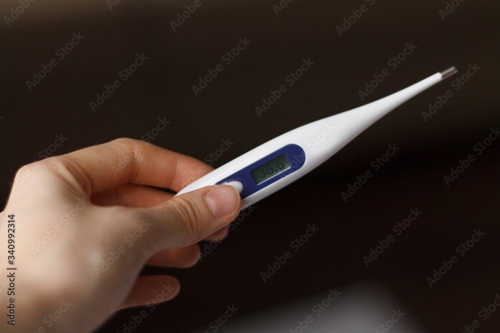 electronic thermometer in hand close up with body temperature electronic thermometer in hand close up with body temperature