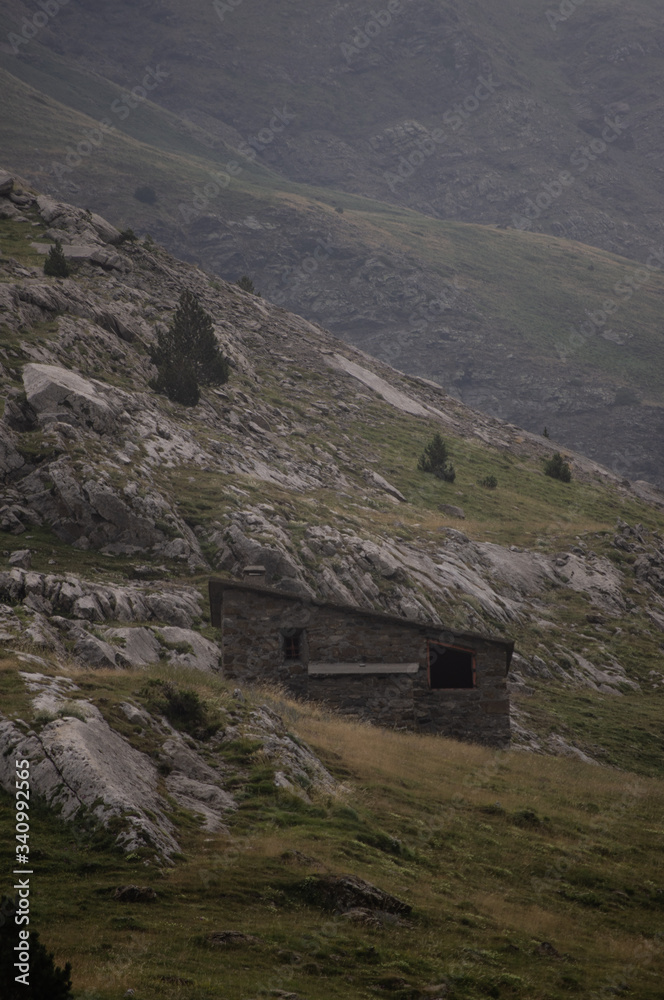Shepherds house lost in the mountains. A shepherd's shelter in the middle of a natural landscape on a cloudy day.