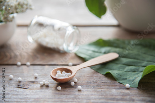 homeopathic granules, medicinal herbs on a natural wooden table on a natural background. alternative medicine and homeopathy