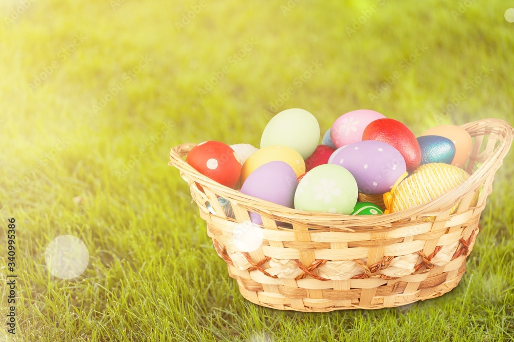 Colored easter eggs in the basket on the green grass Colored easter eggs in the basket on the green grass