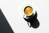 Morning cup of delicious espresso on a white table in sunlight.
