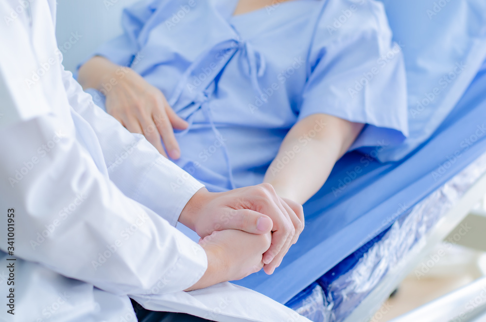 male doctor is holding hands to give encouragement and the contract to cure the old woman in the hospital bed. male doctor is holding hands to give encouragement and the contract to cure the old woman in the hospital bed.