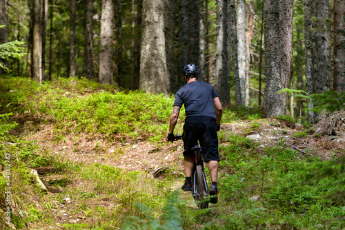 Male cyclist with mountainbike up in forest