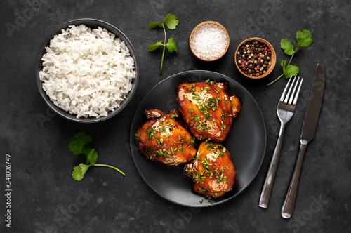 grilled sweet chicken thighs and cooked rice on a stone background. Asian food