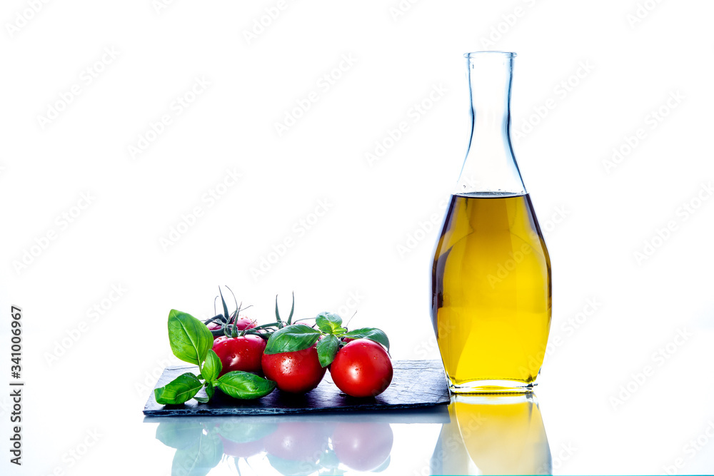 olive oil, tomatoes, basil, garlic, on slate and white background olive oil, tomatoes, basil, garlic, on slate and white background