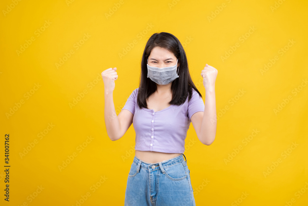 Studio shot Portrait asian woman wearing mask protection against germs from coronavirus and prevent infection, Glad excited emotion after recover from illness covid-19 on yellow background isolated. Studio shot Portrait asian woman wearing mask protection against germs from coronavirus and prevent infection, Glad excited emotion after recover from illness covid-19 on yellow background isolated.